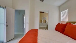 A bedroom with a large bed, an open door leading to a bathroom, and a visible shower area. - Pool home 5 miles to Disney! Great for families! (Kissimmee)
