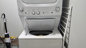 Una lavadora de carga frontal con panel de control, una aspiradora y un radiador.