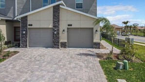 A modern two-story house with a garage, numbered 1097 and 1099, featuring a stone accent wall and a paved driveway. - Championsgate-Free Water park/18 mins DisneyWorld (Davenport)