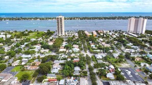 An aerial view of a coastal residential area with multiple buildings, roads, and a marina. - LIT's Palma Home - Near Beach, Downtown, Shopping, & More!! (West Palm Beach)