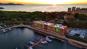 A marina with colorful buildings and boats docked. - Flamingo Bliss: Ocean-View Condo in Luxury Complex - 360 Splendor 204 (Playa Flamingo)