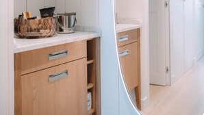 Eine moderne Küche mit Holzschränken, einer Marmorarbeitsplatte und einer Glasschüssel.