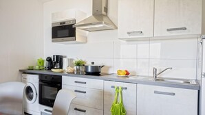A modern kitchen with stainless steel appliances, a built-in oven, a microwave, and a sink. - Casa Ghju (Algajola)