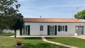 A white building with a tiled roof, green shutters, and a paved driveway. - Villa SAINT MART (11 rue de la Réunion, Saint Martin) (Saint-Martin-de-Ré)