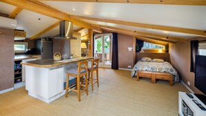 A compact room with a kitchenette, a dining area, and a bed. - Loft 50m² au calme avec vue splendide piscine (Les Adrets-de-l'Estérel)