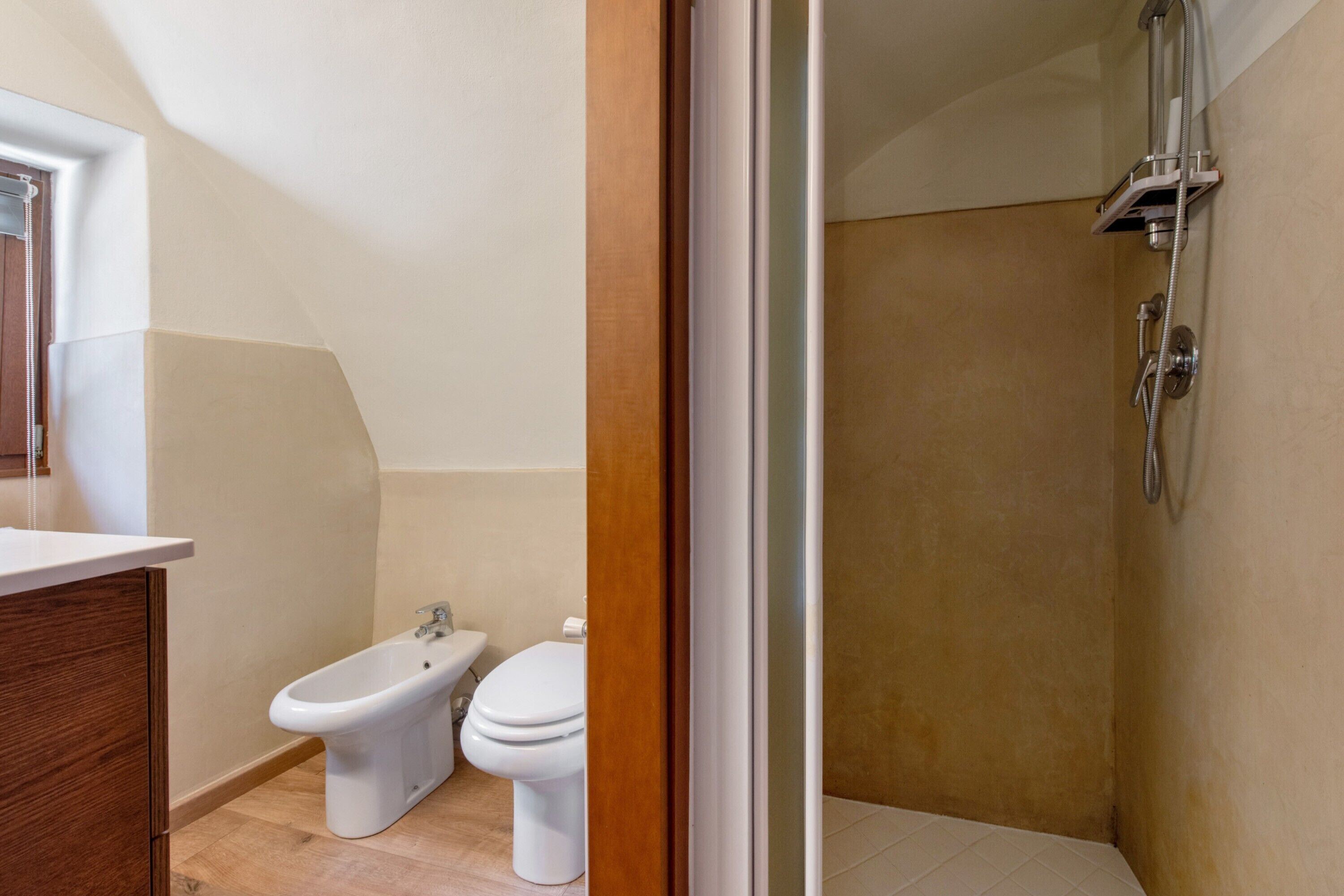 Un baño con bidé, inodoro y ducha.