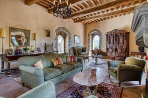 A spacious living room with a green sofa, armchairs, a coffee table, and a chandelier. - Villa 'Castello Di Magrano' with Private Pool, Private Terrace and Wi-Fi (Gubbio)