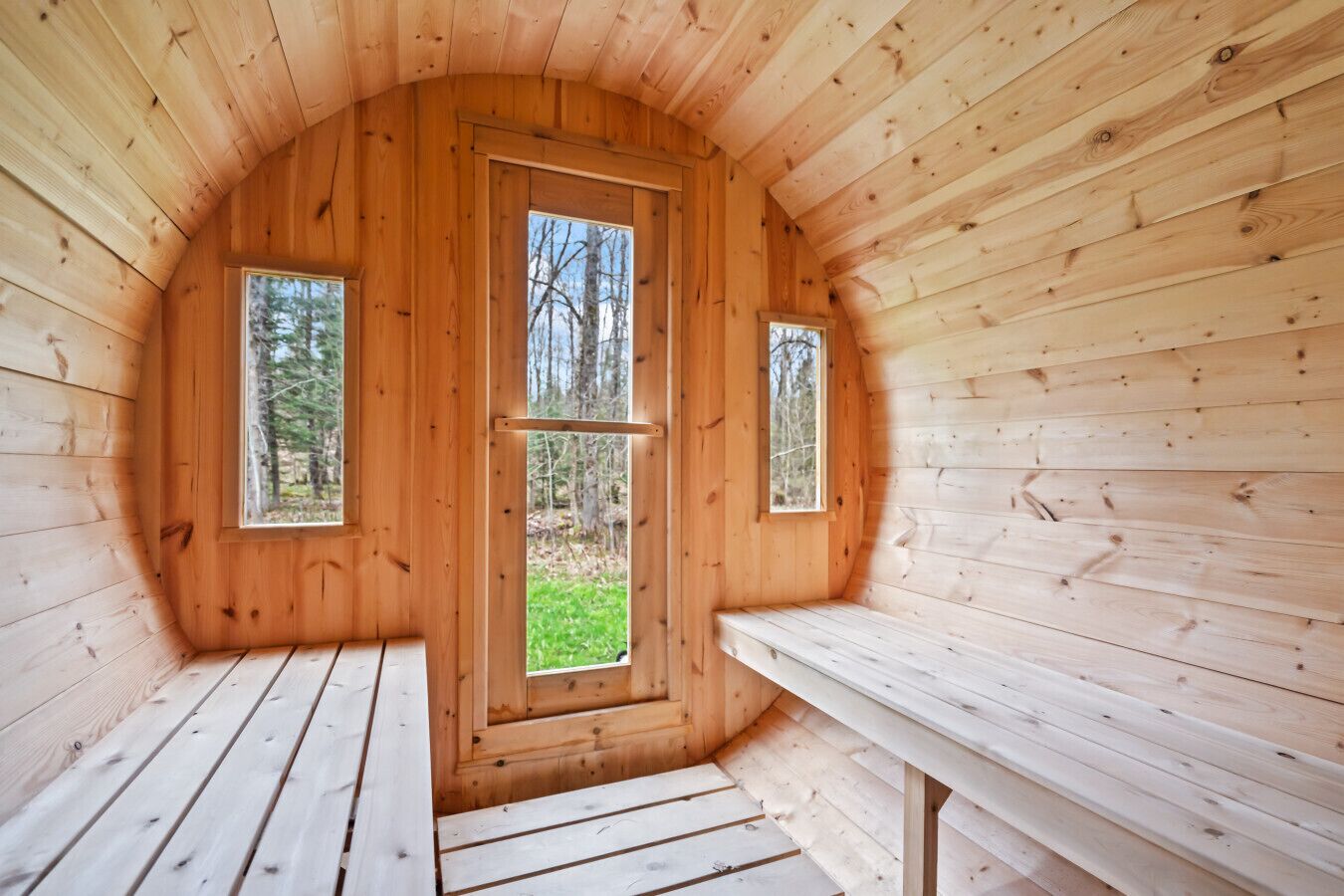 Una cabaña de madera con un banco y una puerta que da a un espacio al aire libre.