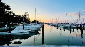 Un port de plaisance où sont amarrés de nombreux bateaux, l’eau est calme et le ciel est dégagé.