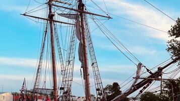 A tall ship docked at a pier with a clear sky.