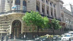 A historic building with ornate architecture, a grand entrance, and a tree-lined street. - obelisco hoteles (Buenos Aires)