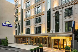 A Days Inn hotel with a classic facade, large windows, and a well-lit entrance. - Days Inn By Wyndham Istanbul Bomonti (Istanbul)