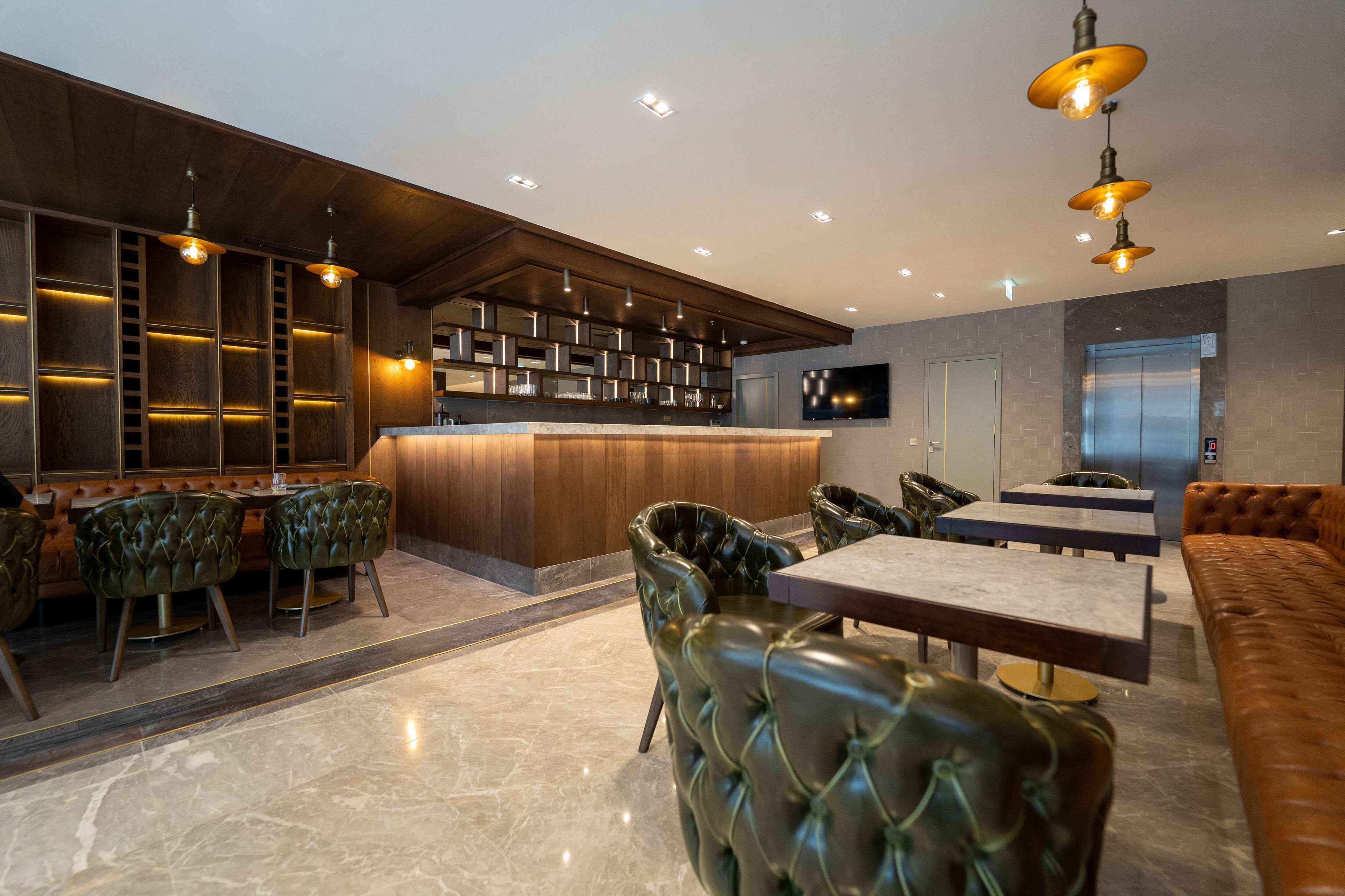 A modern interior with a bar area, leather seating, and a flat-screen TV.