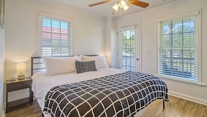 A bedroom with a bed, a nightstand, a ceiling fan, and windows with blinds. - Centrally located to Charleston’s best! (North Charleston)