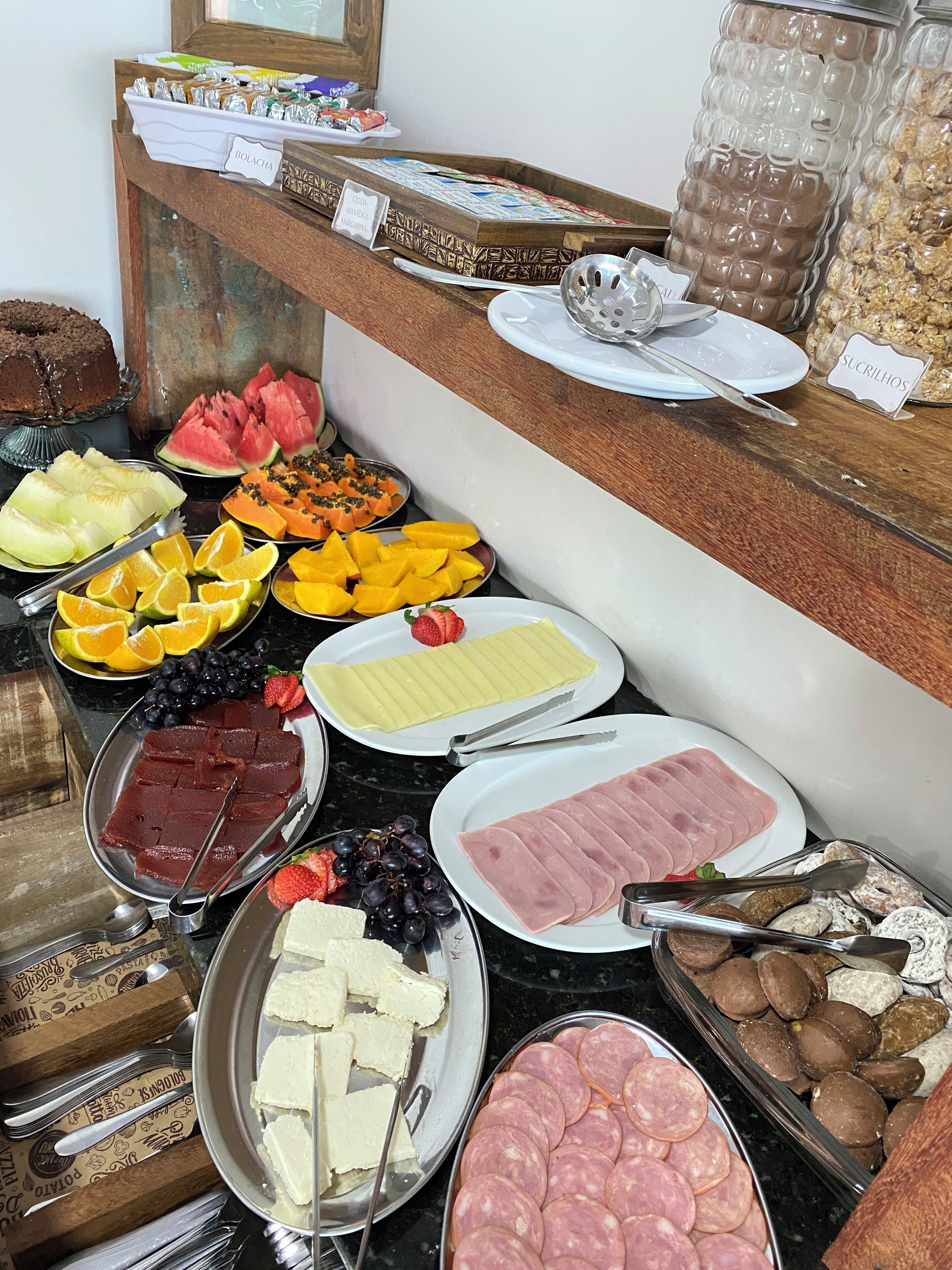 A buffet spread with various food items including fruits, cheeses, and meats.