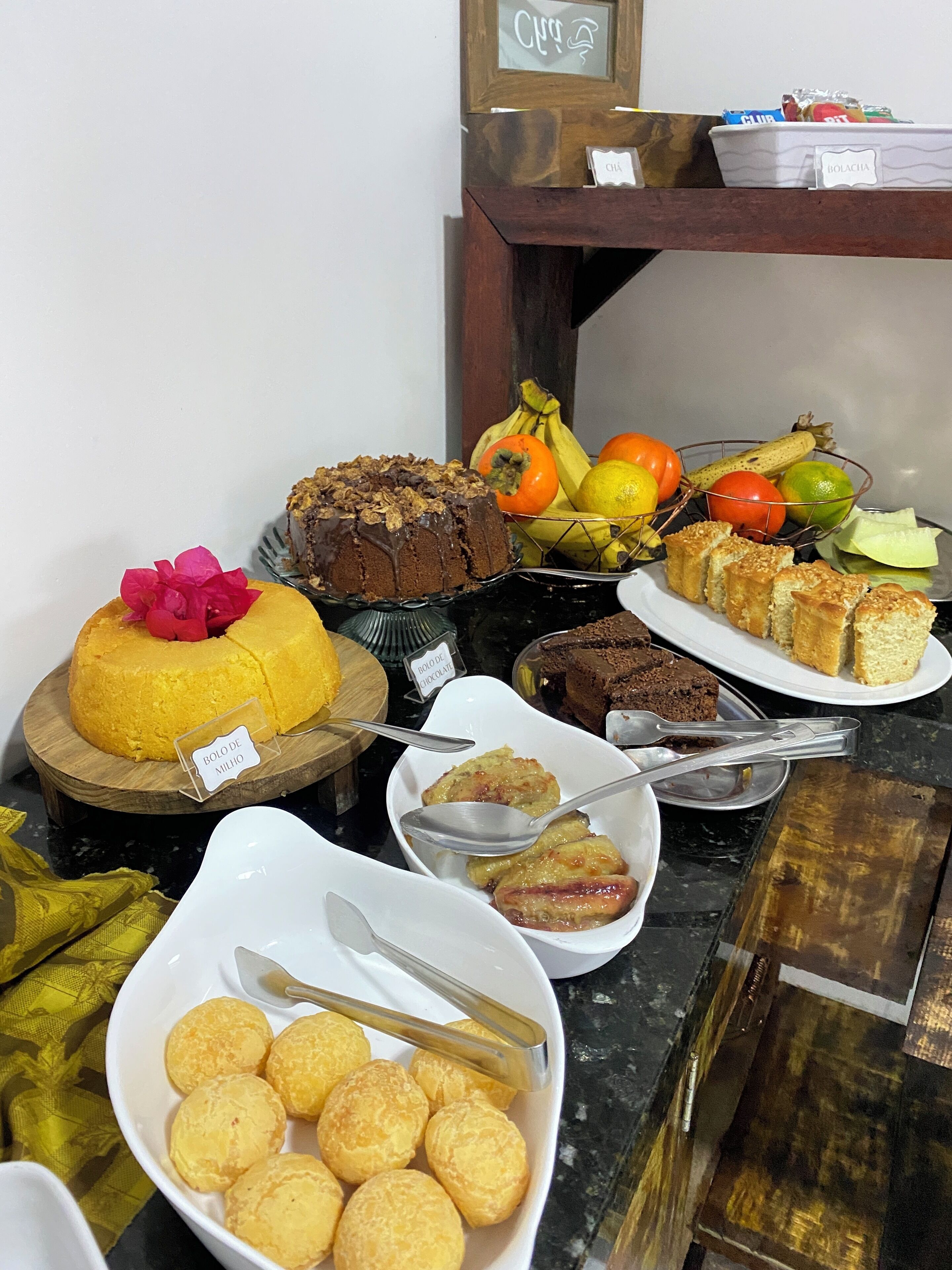 A buffet table with various desserts and fruits.