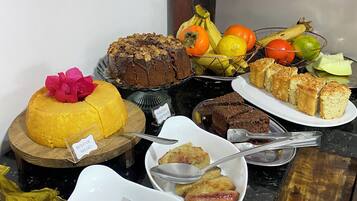 A buffet table with various desserts and fruits.