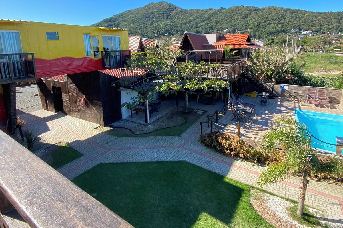 A residential area with a swimming pool, a patio with seating, and a view of a mountain.