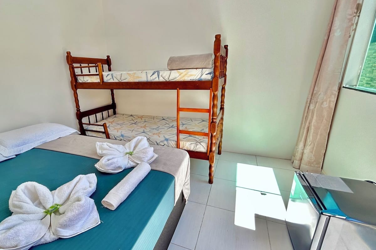 A room with a bunk bed, a desk, and towels on the bed.