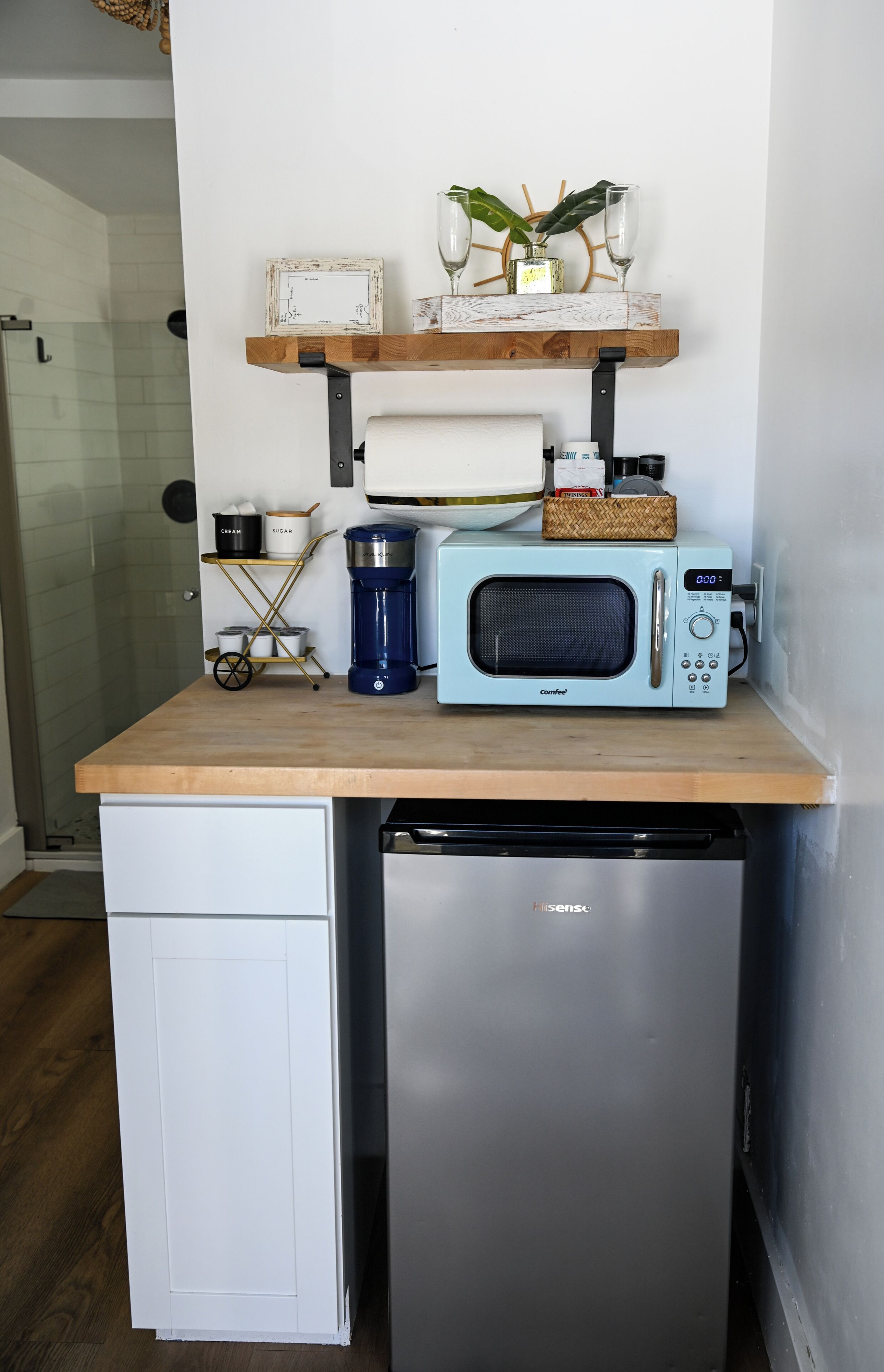 A compact kitchen with a microwave, a coffee maker, and a small refrigerator.