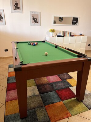 A pool table with a colorful rug, a bookshelf with books, and framed artwork on the wall. - Wonderful  villa with A/C, hot tub, WIFI, sauna, TV, patio, pets allowed and panoramic view (Assisi)