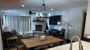 Una sala de estar moderna con chimenea, comedor y cocina.
