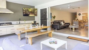 A modern kitchen with a dining area, a sofa, and a coffee table.