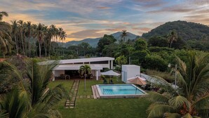 A modern house with a pool, surrounded by lush greenery and palm trees. - Ayanna Beach Front Heaven (La Libertad)