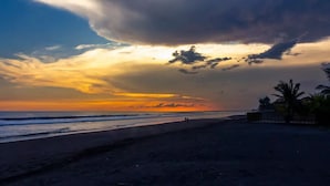 A beach with a clear sky and a sunset.