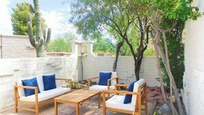 An outdoor patio with wooden furniture and a cactus. - Avenida San Valle, Sabino Canyon (Tucson)