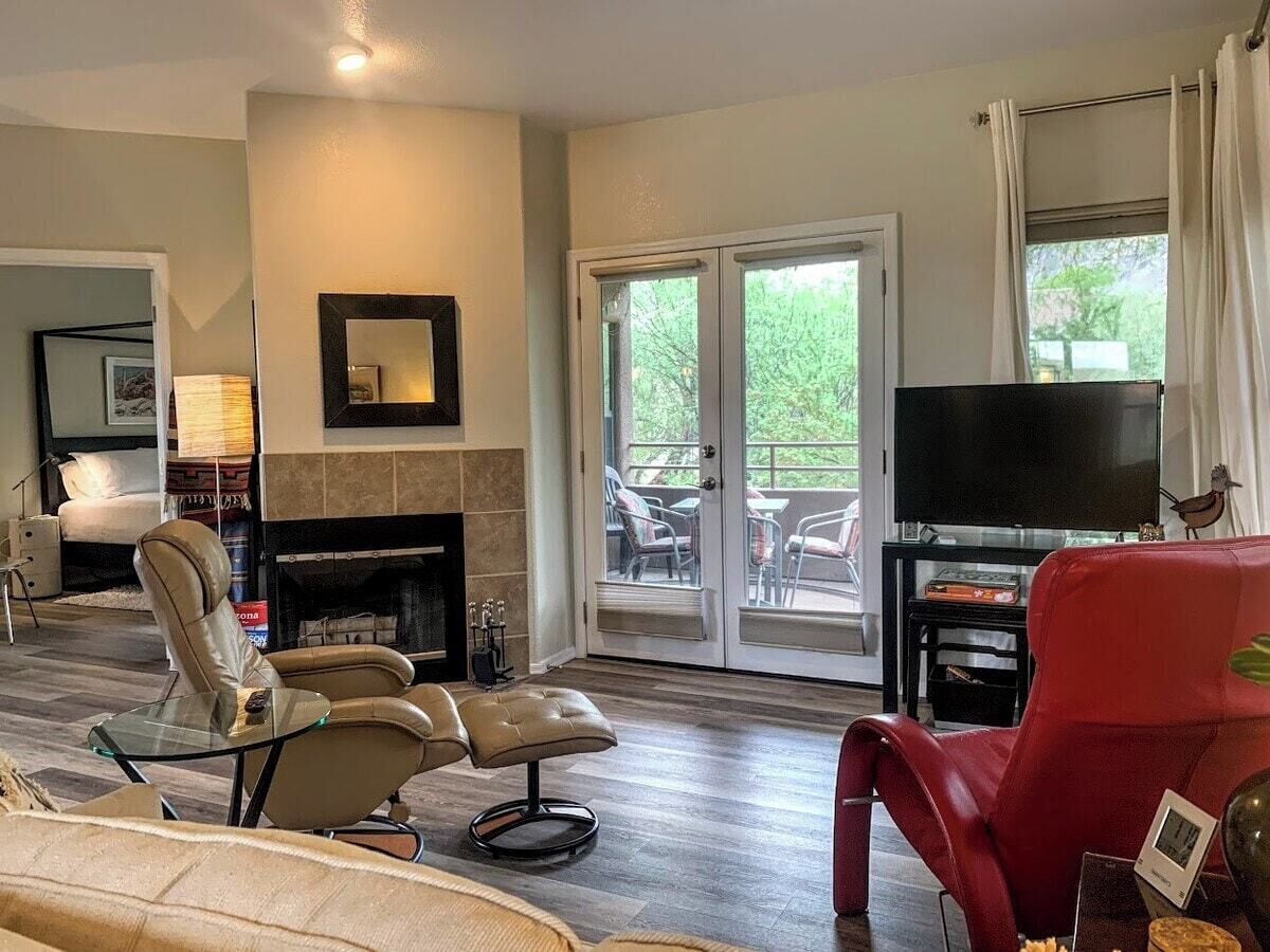 A living room with a fireplace, a television, and a red chair.