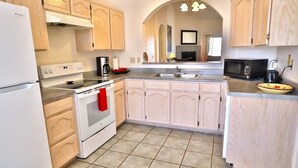 A kitchen with a refrigerator, stove, microwave, and sink. - West Side getaway Jacana Loop (Tucson)
