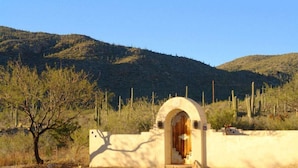 A desert landscape with a single building featuring an arched entrance.