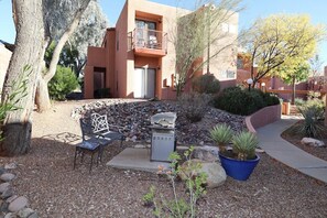 Un quartier résidentiel doté d’un patio, d’un barbecue, de meubles de jardin et d’un petit jardin.