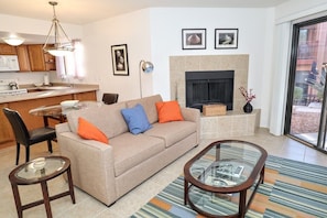 A living room with a sofa, coffee table, and a fireplace. - Ventana Vista 1179 Condo (Tucson)