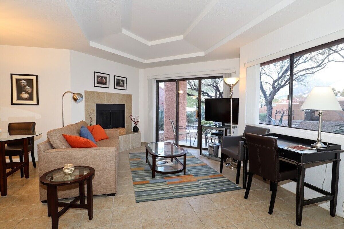 A living room with a sofa, coffee table, TV, and a fireplace.