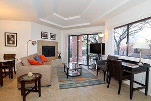 A living room with a sofa, coffee table, TV, and a fireplace.