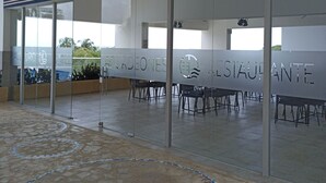 A WAHOO Restaurant at Sierra Beach Resort with a glass wall, outdoor seating, and a tiled floor. - Ocean View Apartment w/ Private Beach & Pools Santa Marta – Pozos Colorados (Santa Marta)