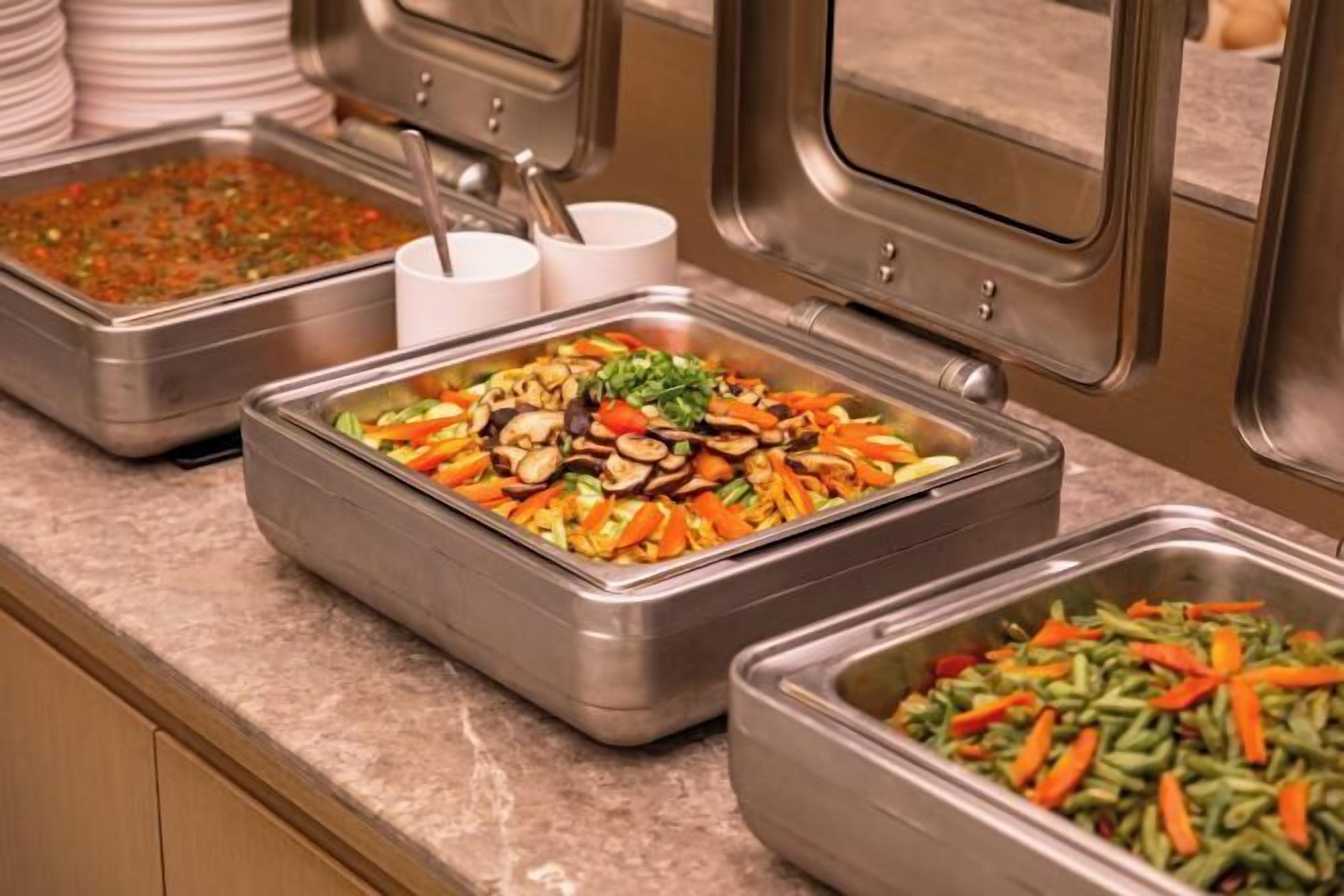 A buffet with various dishes including vegetables and nuts.