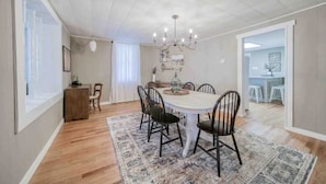 A dining area with a round table, chairs, a chandelier, and a patterned rug. - Vineyard Ridge Farmhouse • 3BR • 2BA • Vineyard View • Fire pit • 
 (Saint James)