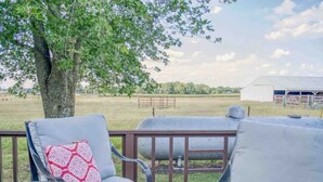 An outdoor deck with two chairs and a fire pit, overlooking a farm and barn. - Vineyard Ridge Farmhouse • 3BR • 2BA • Vineyard View • Fire pit • 
 (Saint James)
