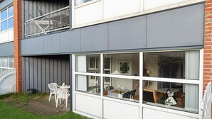 A modern two-story building with large windows and a balcony.