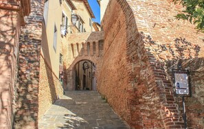 A narrow cobblestone alleyway flanked by historic brick buildings with arched doorways and a signboard. - Amazing home in Casciana Terme Lari (Casciana Terme Lari)