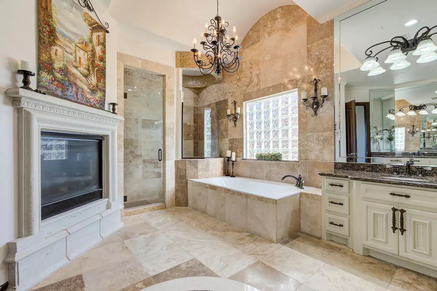 Un baño espacioso con una bañera grande, un vestidor con ducha y una chimenea.