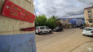 A street scene with a red sign indicating a Casa Voyage hotel and a telephone number.