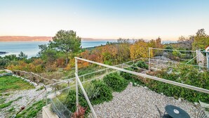 A scenic outdoor area with a view of the sea, a wooden fence, and a gravel path. - Beautiful apartment in Gondolici (Gondolici)