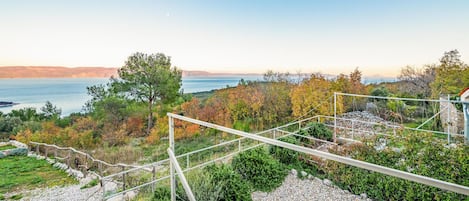 A scenic outdoor area with a view of the sea, a wooden fence, and a gravel path.