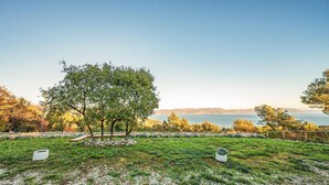 A grassy area with a large tree and a stone wall. - Beautiful apartment in Gondolici (Gondolici)