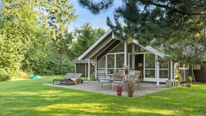 A modern house with a covered patio, outdoor seating, and a lawn. - 4 bedroom beautiful home in Melby (Melby)
