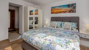 Une chambre à coucher avec un lit, des tables de chevet, une armoire et un tableau accroché au mur.